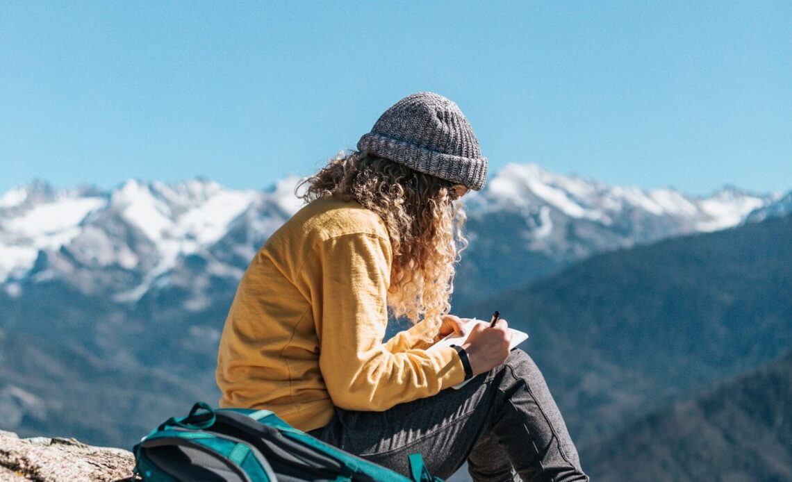 A hiker journaling in the mountains (photo: Tyler Nix)