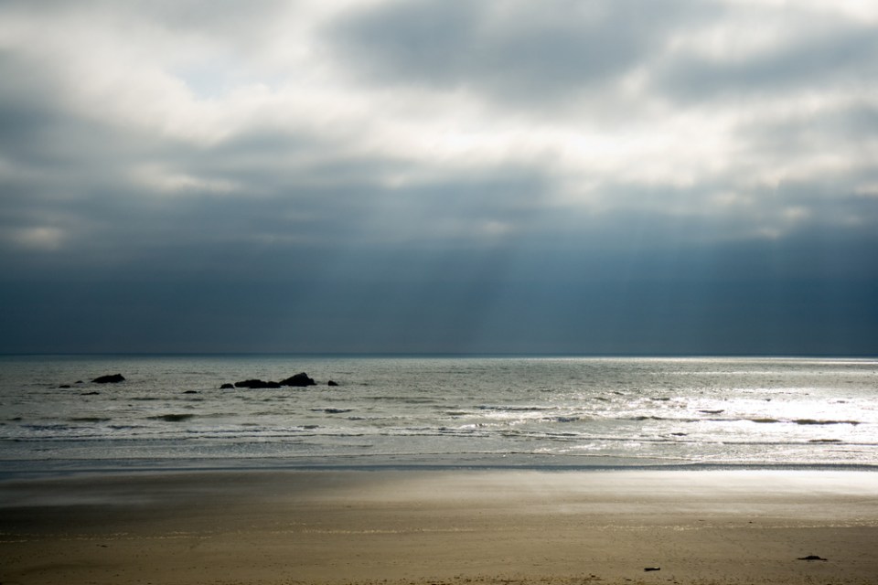 Evening sun streams through a heavy cloud cover at Kalaloch Beach. Olympic National Park, WA