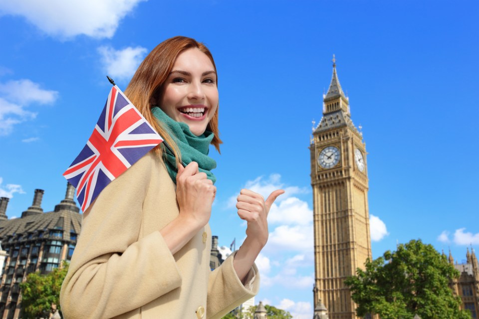 Happy woman travel in London with Big Ben tower, and smile to you, caucasian beauty