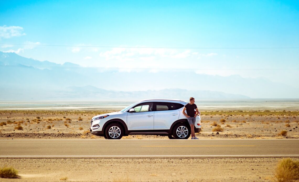 A key car rental tip is choosing the right type of vehicle for your trip. Pictured: car and driver in Death Valley, USA (photo: Jamie Street)