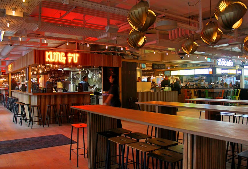 Stools are tucked in under wooden benches waiting for diners at the Tivoli Food Hall.