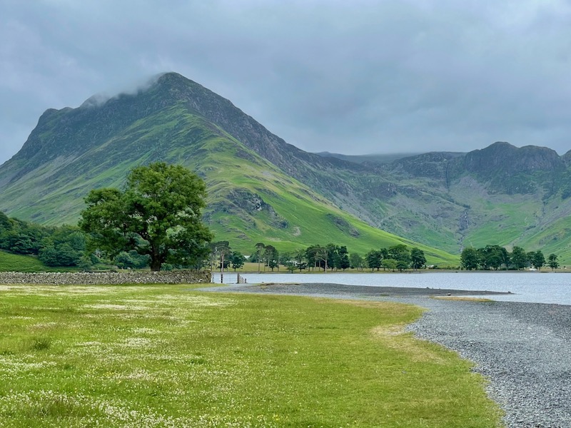 Lake with rugged green mountain in the background at the Lakes District in the UK