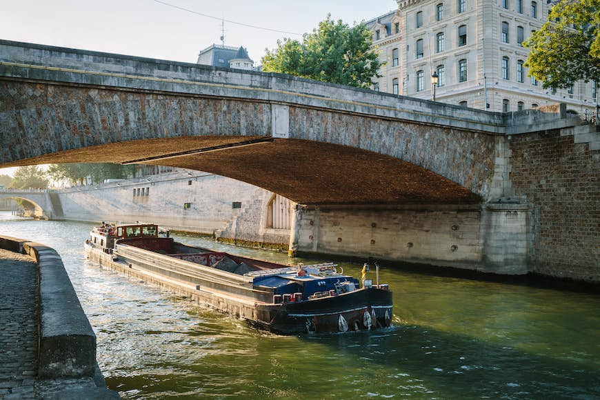 The Petit Pont over the Seine river and a barge in Paris, France