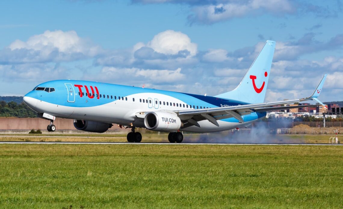 Fire engines surround plane at Manchester Airport as smoke billows from engines