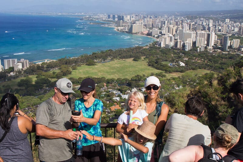 womand girl at the summit of the Diamond Head Walk with views of the buildings Waikiki