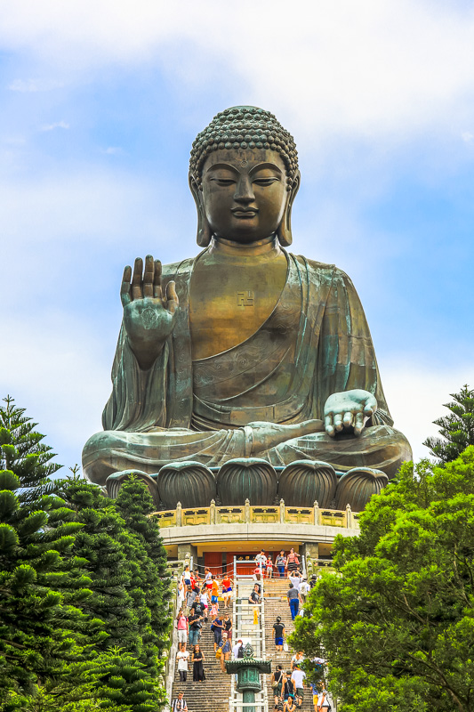 tourists walking up steep stairs to Tian Tan Buddha