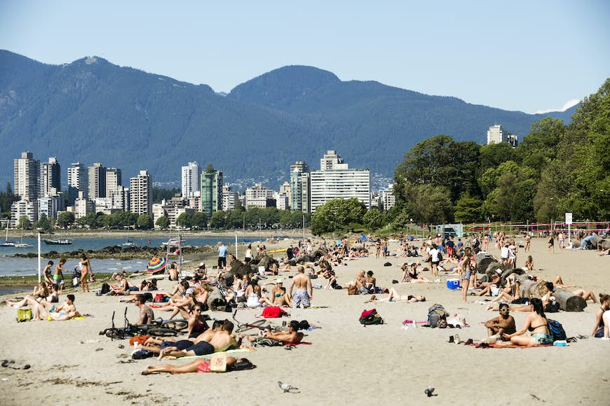 People laying on the sand at Kitsilano Beach, Vancouver