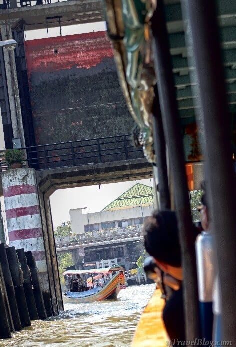 person riding long tail boat bangkok klong