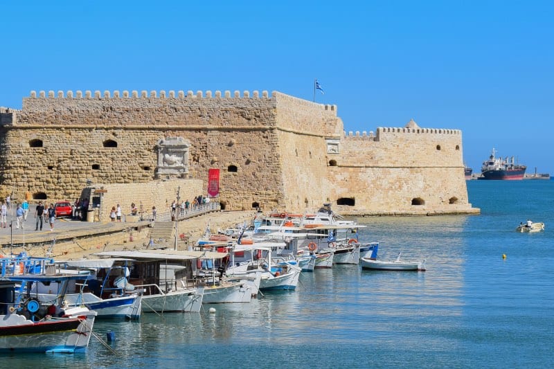 the stoned Venetian Fortress of Heraklion, on the dge of the water with boats docked in front of it