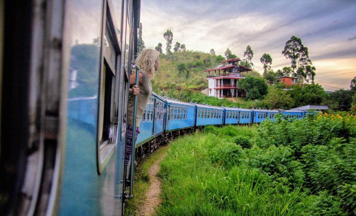 A woman on a train traveling around lush Sri Lanka