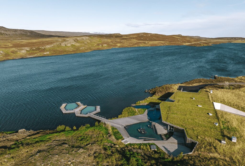 An aerial view of a series of pools on the edge of lake, with two hexagon-shaped pools right in the lake water.