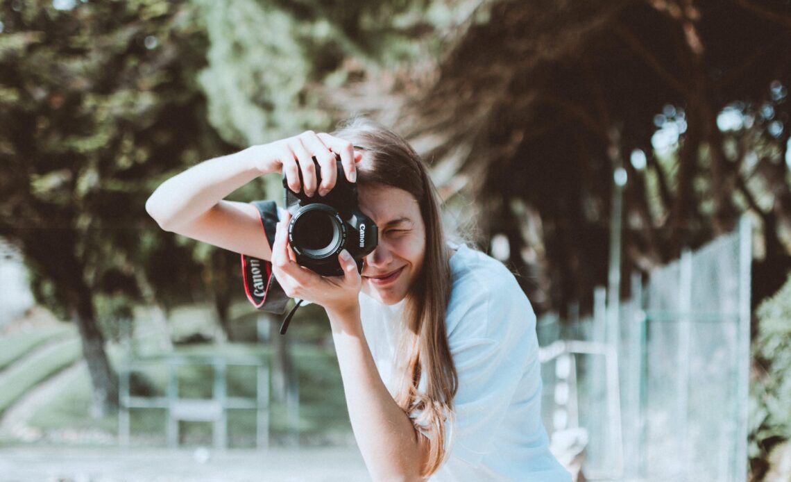 A woman practicing her travel photography with a Canon DSLR camera (photo: Lisa Fotios)