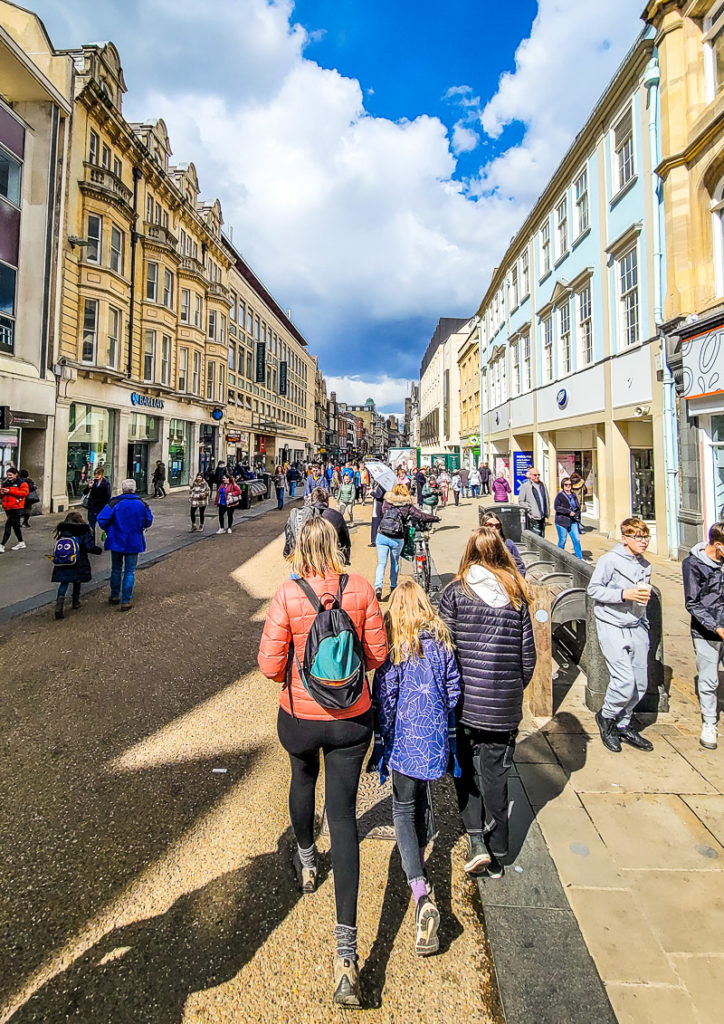 A group of people walking on a sidewalk