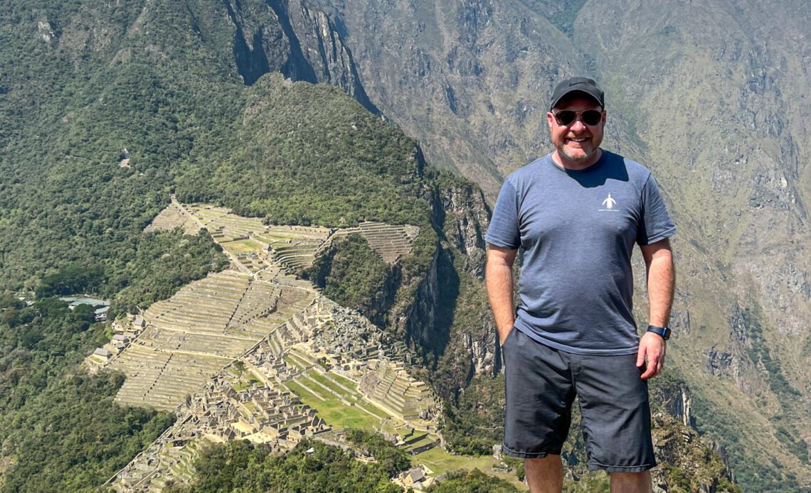 Dave in Peru standing atop Huayna Picchu with Machu Picchu below.
