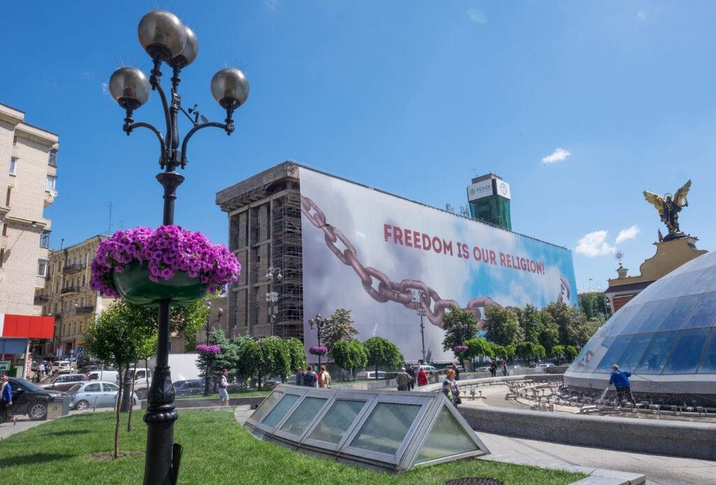 A building in Kyiv with a mural reading "Freedom is our religion."