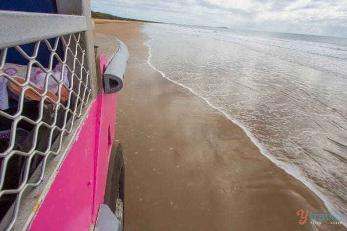 pink truck driving on the sand