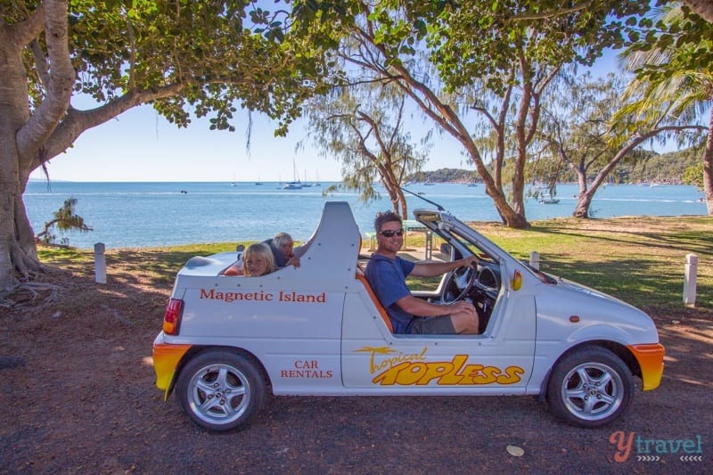 A mini moke parked in front of a lake