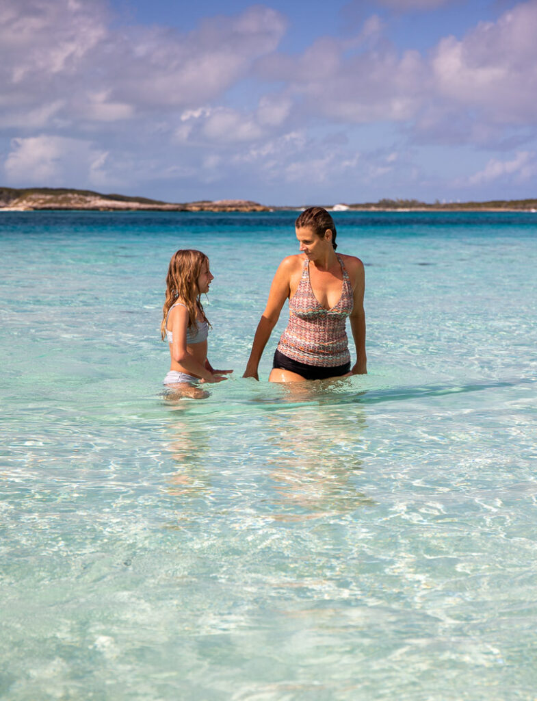 Mom and daughter standing in water at a beach