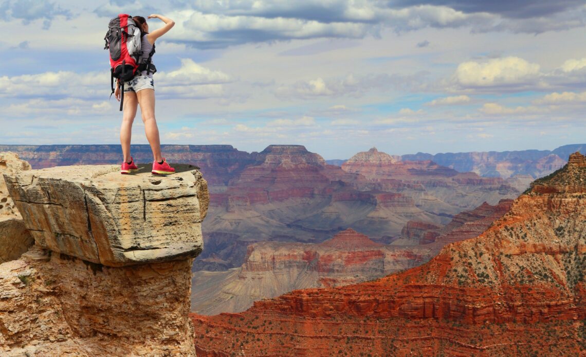 Woman mountain hiker with backpack enjoys views across the Grand Canyon