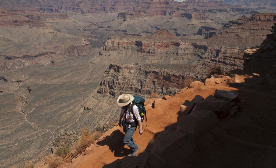 Woman hiking the Grand Canyons Kaibab Trail on the South Rim of the Grand Canyon National Park. rizona, Nature, Mountain, Adults Only, Women, Mid Adult, Cliff, Physical Geography, Arid Climate, One Mid Adult Woman Only, South Rim, Grand Canyon National Park, Hat, Arizona, Extreme Terrain, Tranquility, Landscape, Outdoors, High Angle View, Color Image, Desert, People, Landscape - Scenery, USA, Hiking, Southwest USA, Tasm