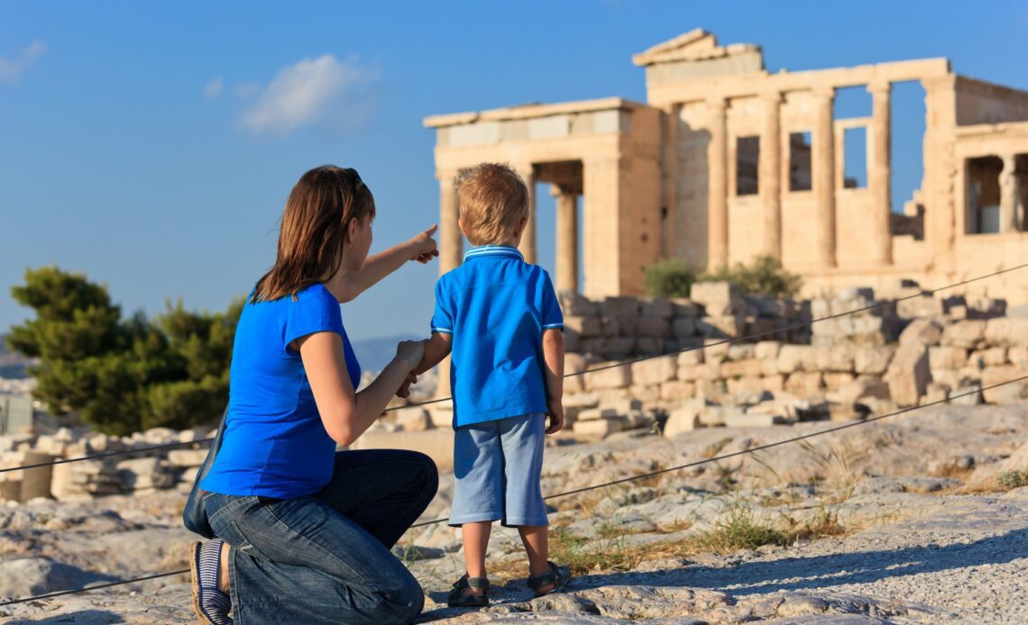 A mother showing her young son the acropolis in Athens, Greece, on a sunny day