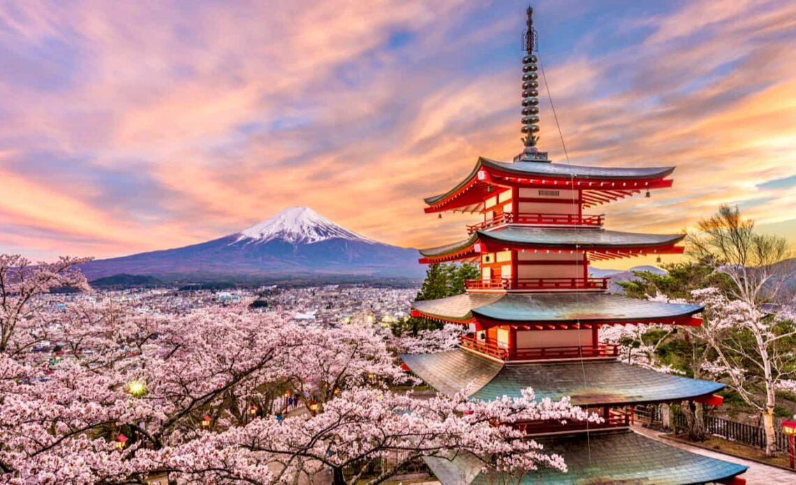 A towering, colorful pagoda in the foreground with beautiful Mount Fuji in the distance in Japan