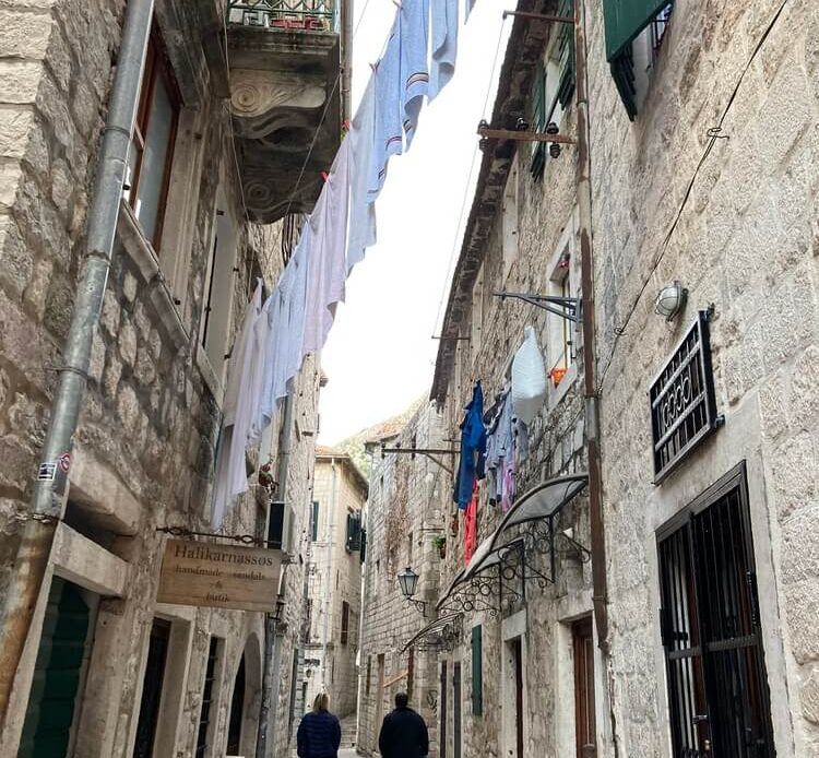 people walking down narrow alleyway