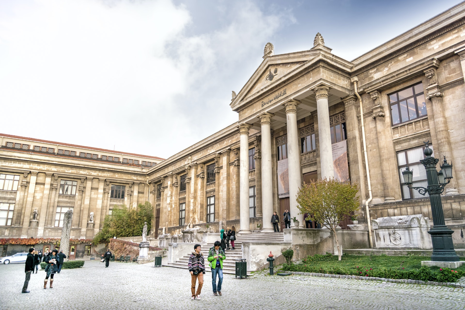 Pedestrians outside of the Istanbul Archaeology Museums on a cloudy day