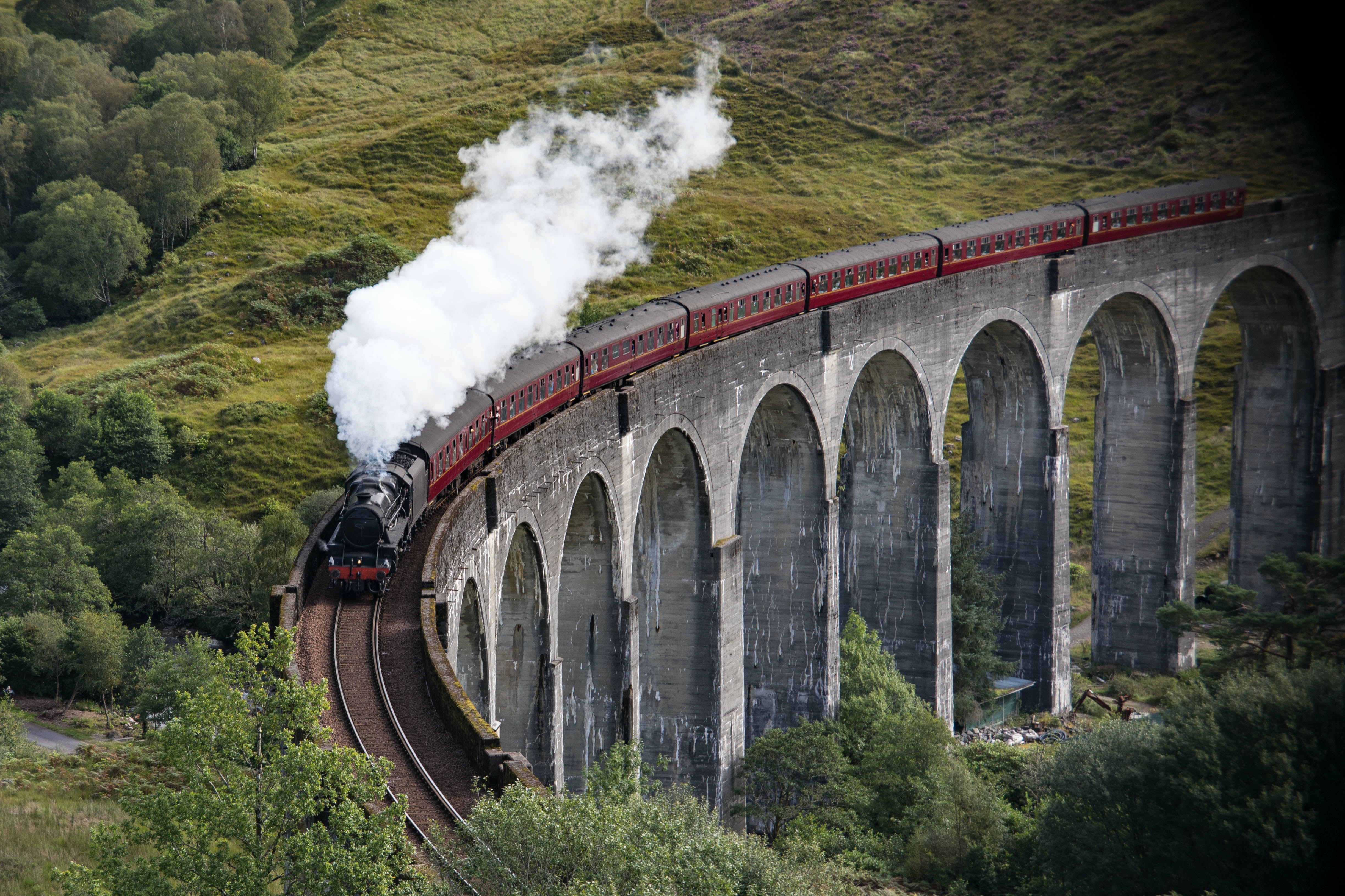 A steam train drives over the viaduct at Glenfinnan, Scotland