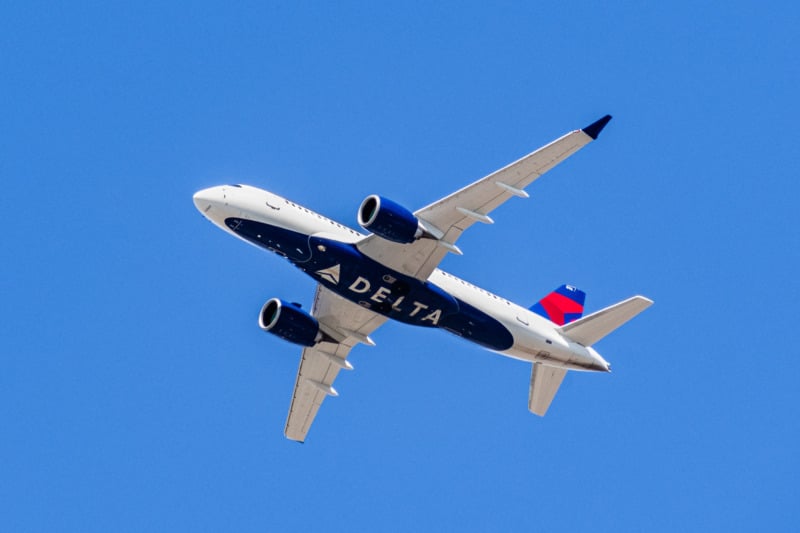 Delta Airlines jet from below against a blue sky background
