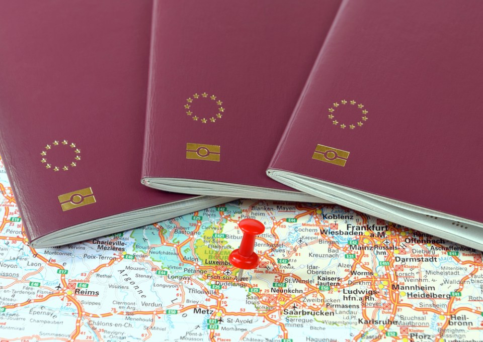 Schengen on the map marked with a red a pin and EU passports
