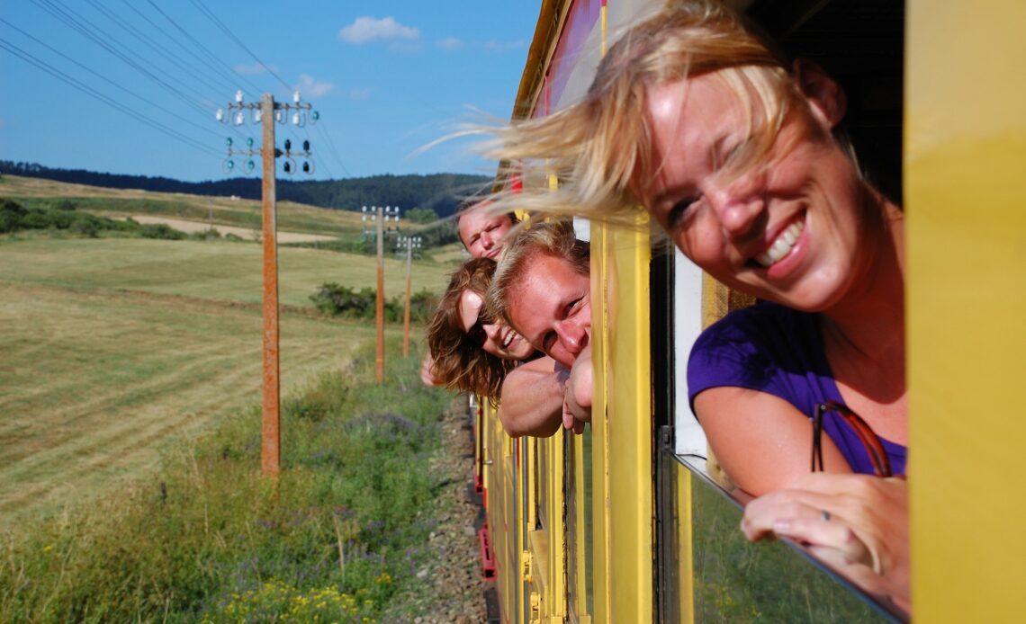 Travelers leaning out the windows of the yellow train in the Pyrenees