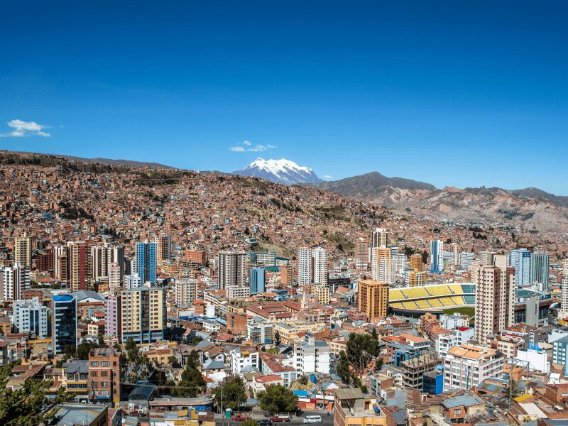A view of a city with snow capped mountains in the background