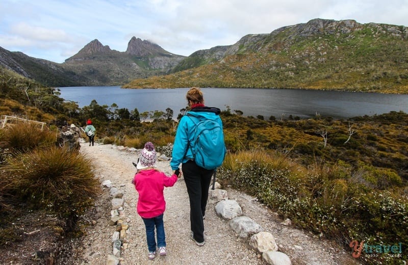 woman and girl holding hands walking around dove lake