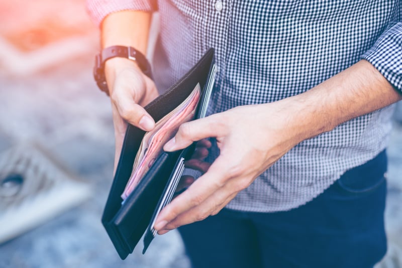 Person opening cash-filled wallet