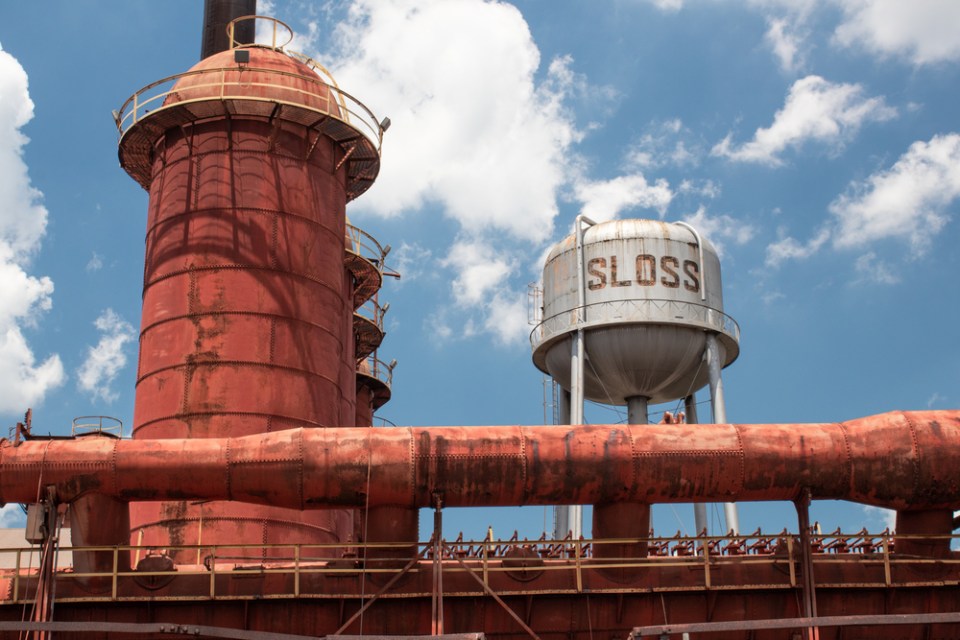 Sloss Furnaces National Historic Landmark, Birmingham Alabama USA, wide view of furnace and water tower against a brilliant blue sky with white clouds, horizontal aspect