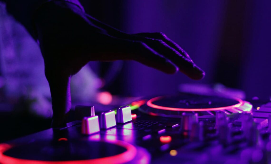 A turntable at a rave with neon lights