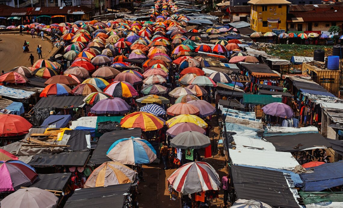 Hundreds of brightly colored umbrellas provide shade to shoppers at a busy market place