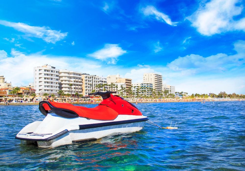 The beautiful Finikoudes beach with some architecture in the area under a clear blue sky.