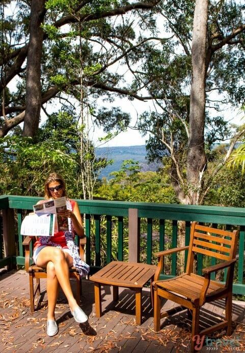 woman sitting on deck reading a pamphlet at Binna Burra Mountain Lodge,