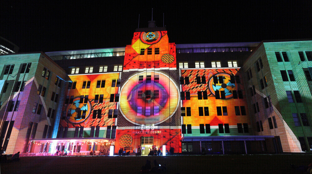 exterior of museum of contemporary art australia lit up with murals at night