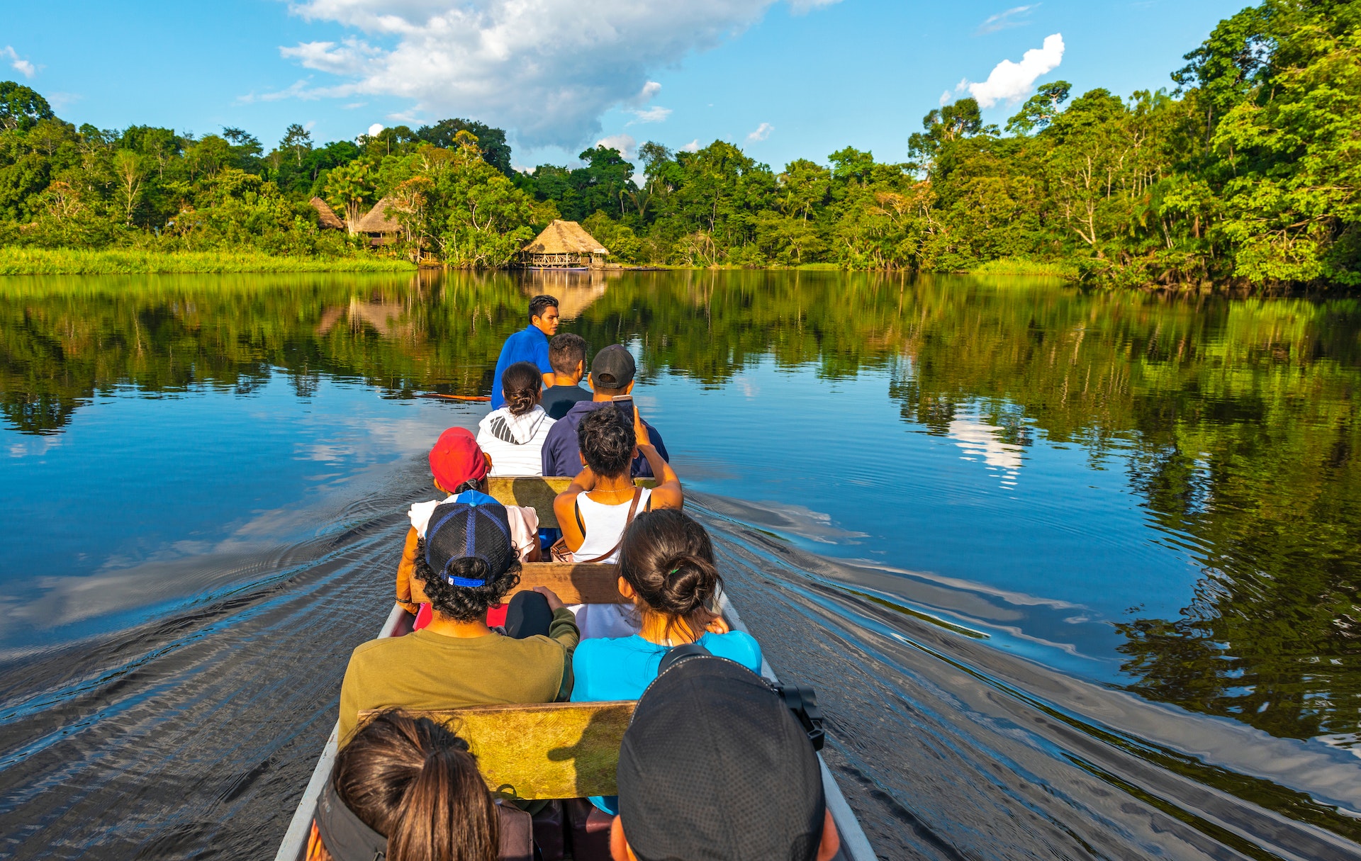 Passengers in a traditional canoe along the rivers of the Amazon River Basin inside Yasuní National Park, Ecuador, South America