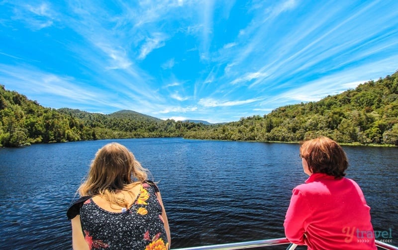 people standing on a bridge looking at a river