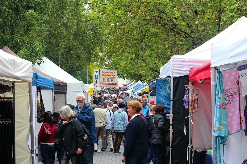 A group of people walking down a market