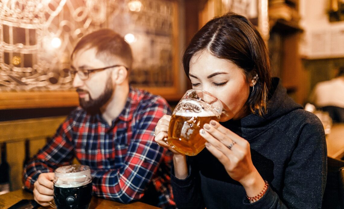 A woman and her friends try freshly brewed authentic Czech beer in a tavern in Prague