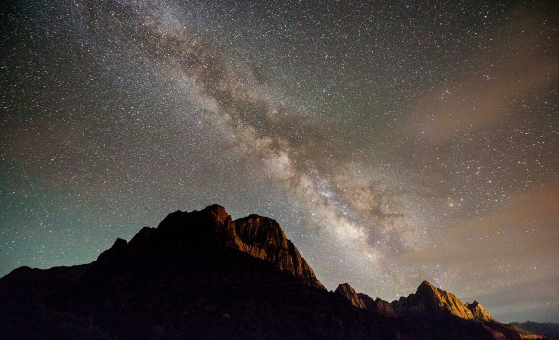 Milky Way night sky shines over the Watchman in Zion National Park.