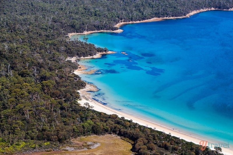 blue waters and white sand of hazards beach as viewed from above