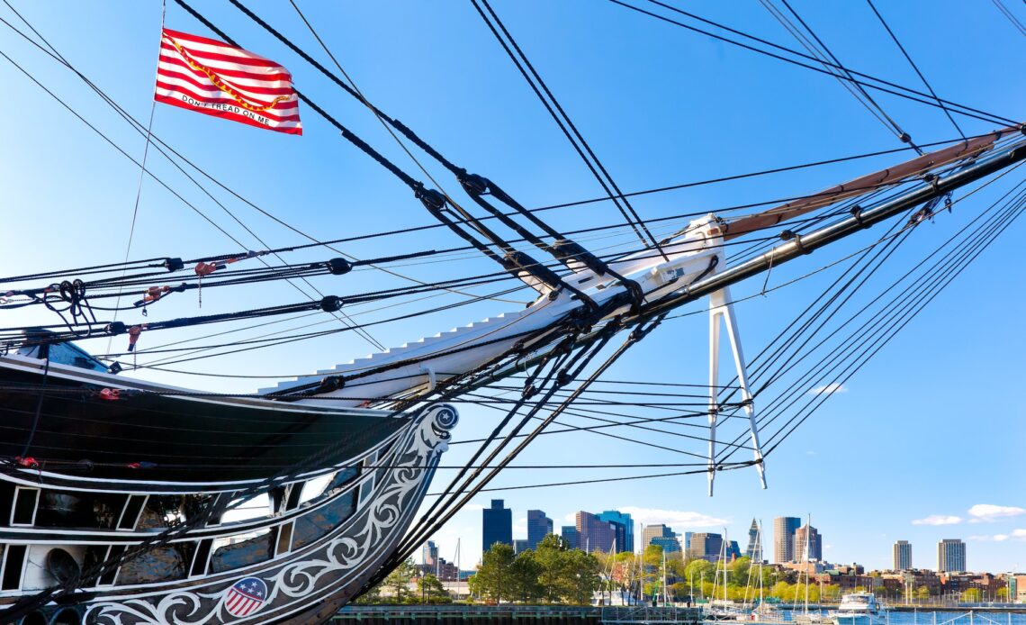 The bow of the USS Constitution rising against the cityscape