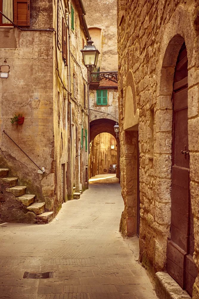 Narrow street of medieval ancient tuff city Pitigliano, travel Italy background