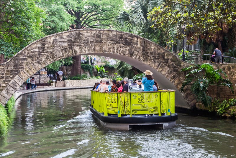 boat going under stone bridge